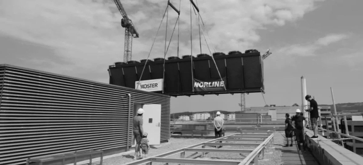 Lüftungsgeräte am Kran über einer Baustelle